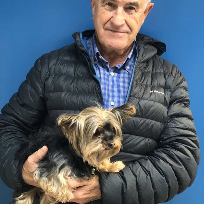 Señor con un perro yorkshire terrier en brazos en la clínica veterinaria El Jardín.