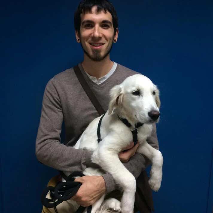 Chico con un perro golden blanco en brazos en la clínica veterinaria El Jardín.